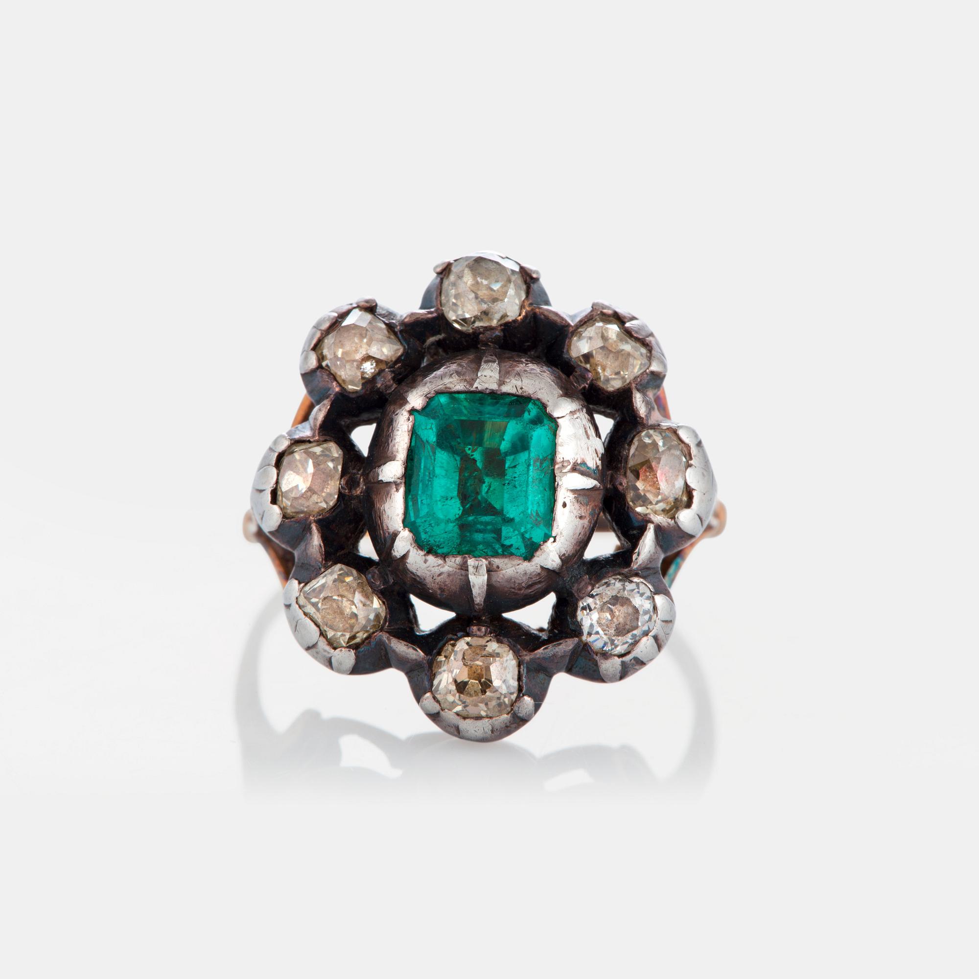 A ring set with an emerald and old-cut diamonds.