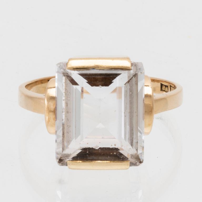 An 18K gold ring set with a step-cut synthetic white spinel.