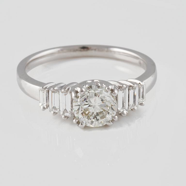 RING, 18K vitguld med briljantslipad diamant ca 1.01 ct samt baguetteslipade diamanter ca 0.29 ct. Vikt 4,0 gram.