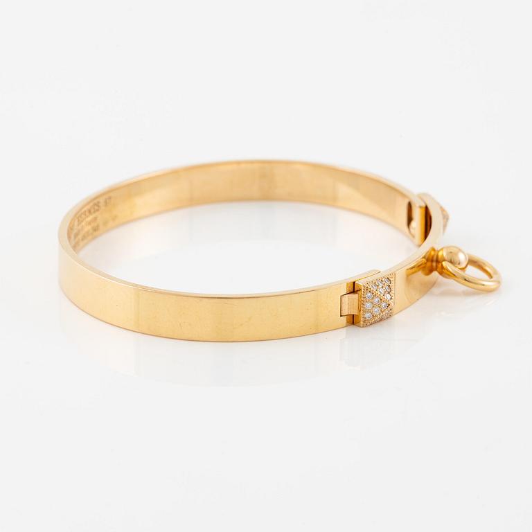 Hermès a bangle "Collier de chien" in 18K gold with round brilliant-cut diamonds.