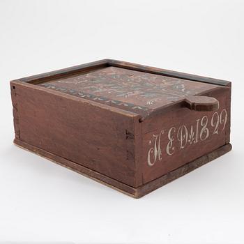 A Swedish folk art painted box with sliding lid, dated 1829.