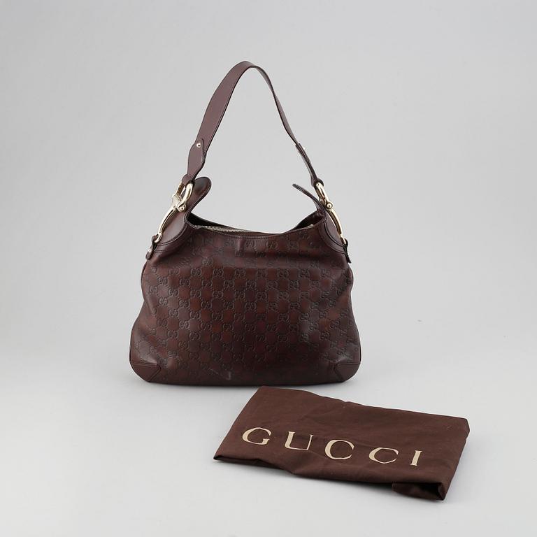 Gucci, a leather bag.