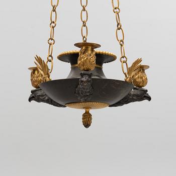 A Swedish Empire ormolu and patinated three-branch chandelier, Stockholm, early 19th century.