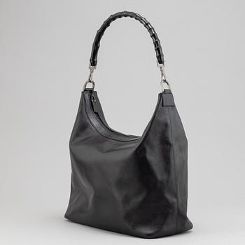 Gucci, a black leather handbag.