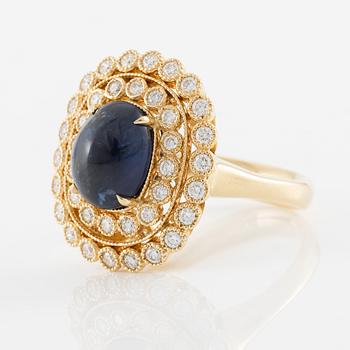 Ring in 18K gold with cabochon-cut sapphire and brilliant-cut diamonds.