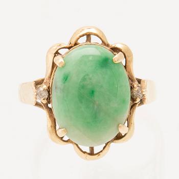 Ring in 14K gold with a green oval cabochon-cut stone and round brilliant-cut diamonds.