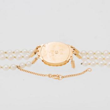 Halsband treradigt med odlade pärlor samt lås av 18K guld.