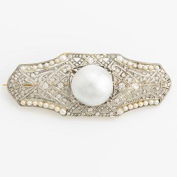 Brooch in 18K gold and platinum with a cultured half-pearl, pearls, diamonds in various cuts, and white stones.