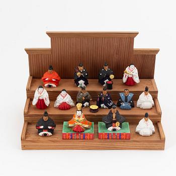 A group of Japanese dolls and lacquered miniature furniture in wooden crates, early 20th Century.
