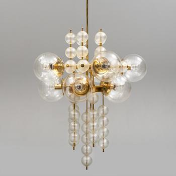 A 1970s brass ceiling light with glass shade. Height ca 144.