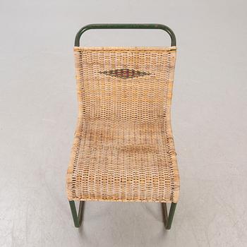 A 1930s braided rattan and metal chair.