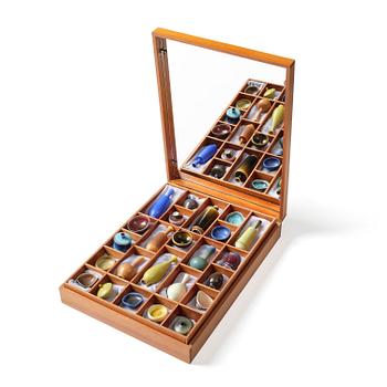 82. Berndt Friberg, a teak casket with 24 stoneware miniatures, Gustavsberg Studio, Sweden.