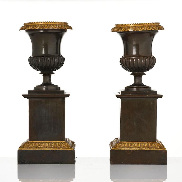 A pair of French Empire ormolu and patinated bronze urns, circa 1820.