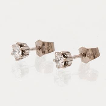 A pair of 18K white gold earrings set with round brilliant cut diamonds.