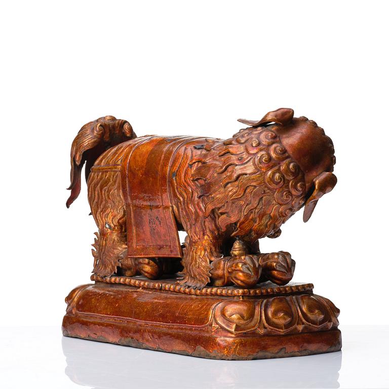 A cold gilt and lacquered copper alloy sculpture of a buddhist lion, Tibeto-Chinese/Mongolian, 18th Century.