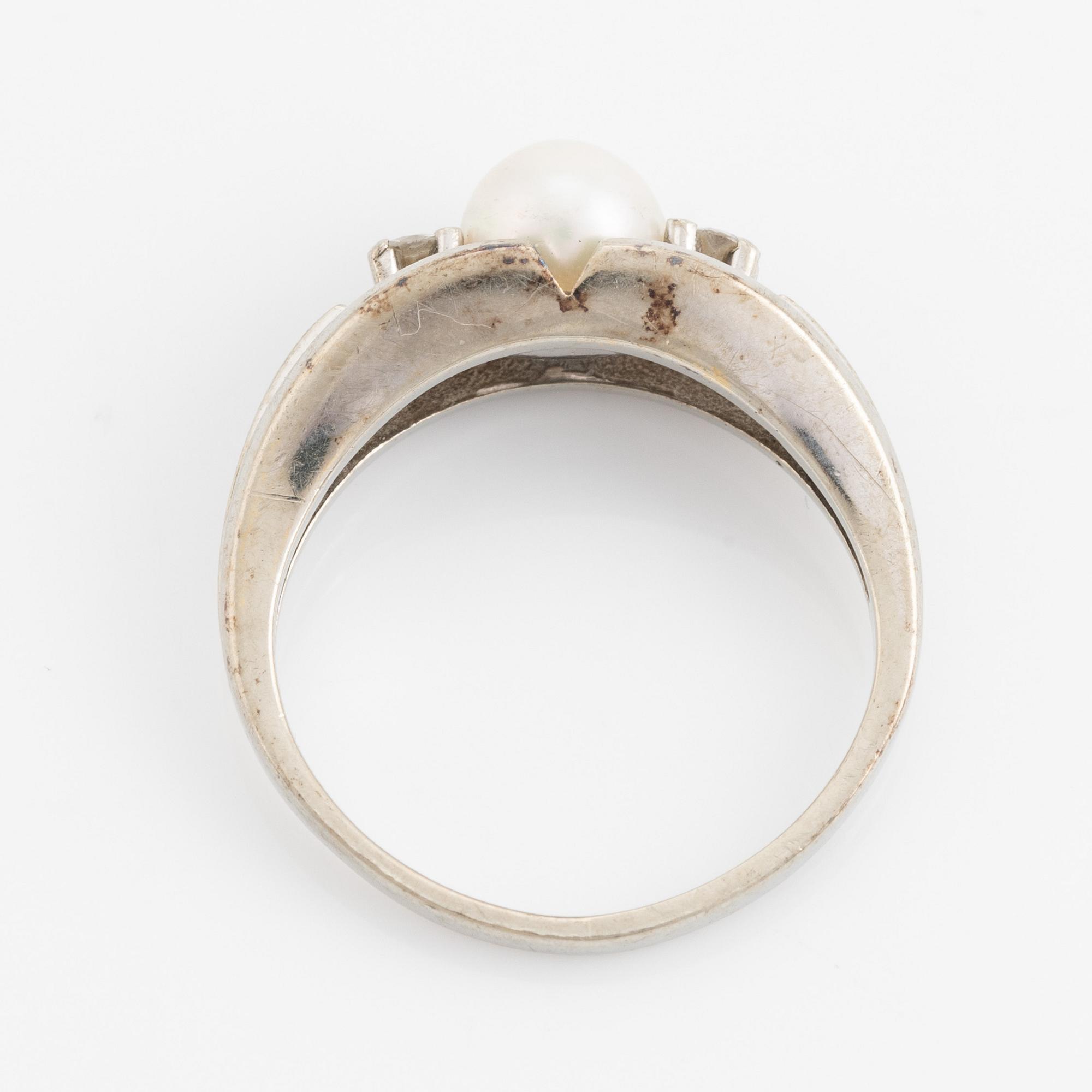 Ring med pärla och två briljantslipade diamanter.