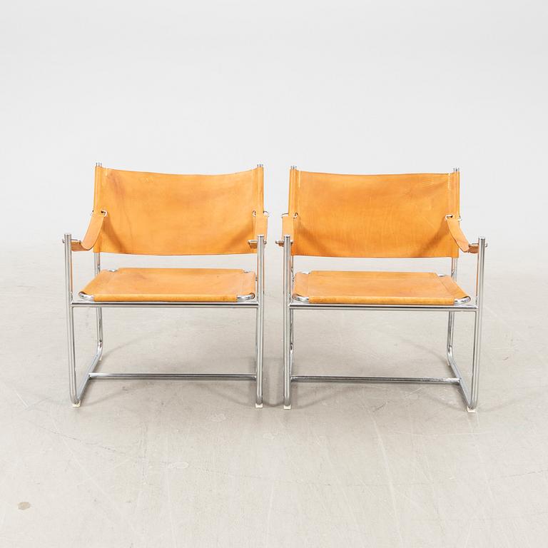 A pair of metal and leather arm chairs by DUX.
