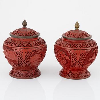 A pair of Chinese urns with cover, a pair of bookstands, a vase and a bowl, lacquer, later part of the 20th century.