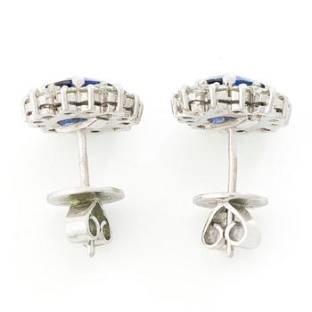 A pair of 14K gold earrings with faceted sapphires and round brilliant- and princess-cut diamonds.