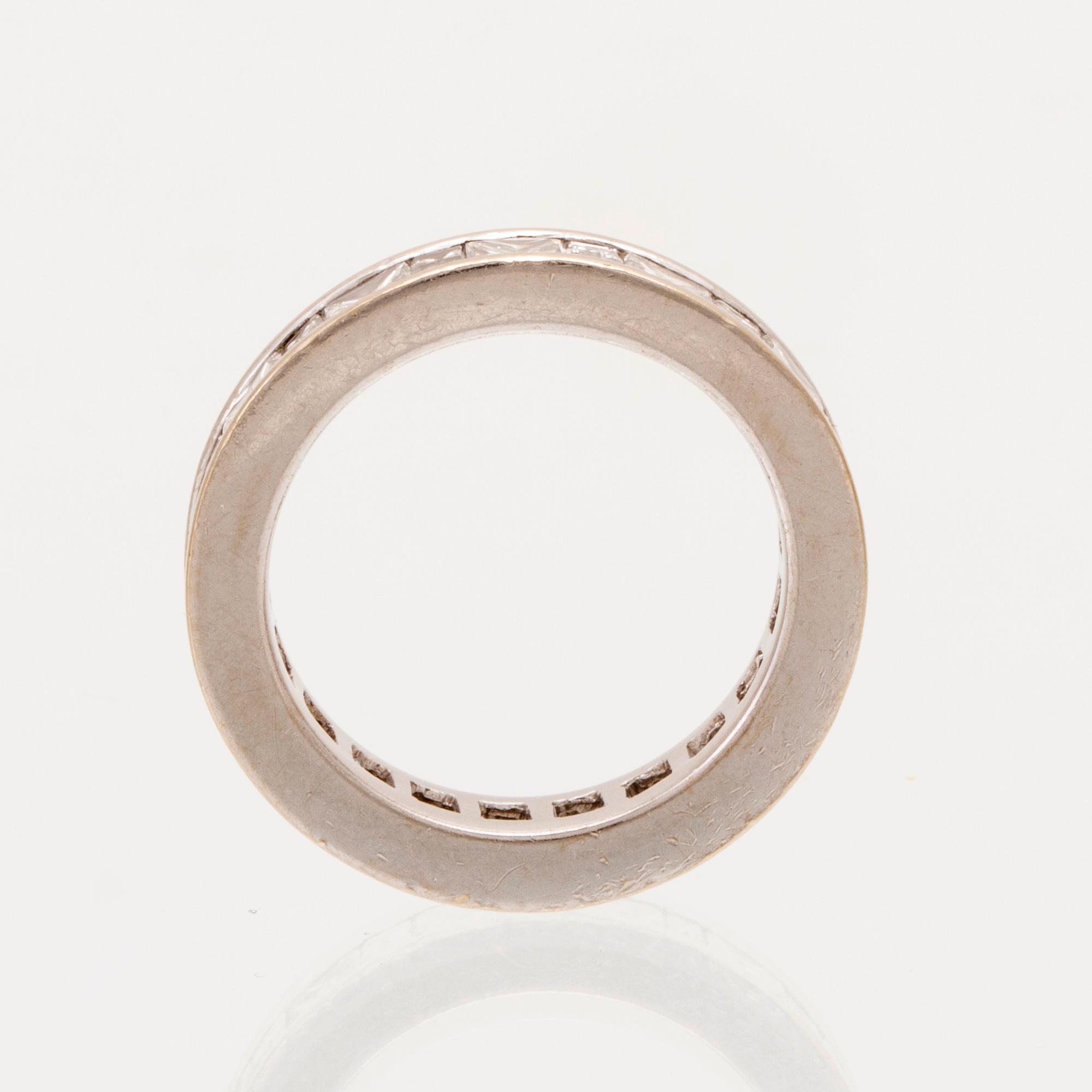 An 18K white gold eternity ring set with baguette and princess cut diamonds by Hartmann's Denmark.
