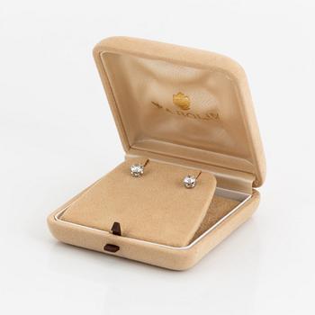 A pair of 18K white gold earrings set with two round brilliant-cut diamonds.