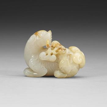 A carved nephrite figure of a reclining dragon carrying lingzhi fungus in his mouth, Qing dynasty (1644-1912).