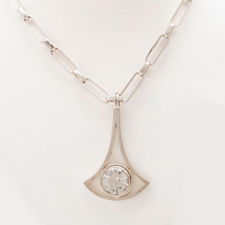 A silver necklace set with a round faceted rock quartz crystal by Göran Kuhlin Gothenburg 1971.