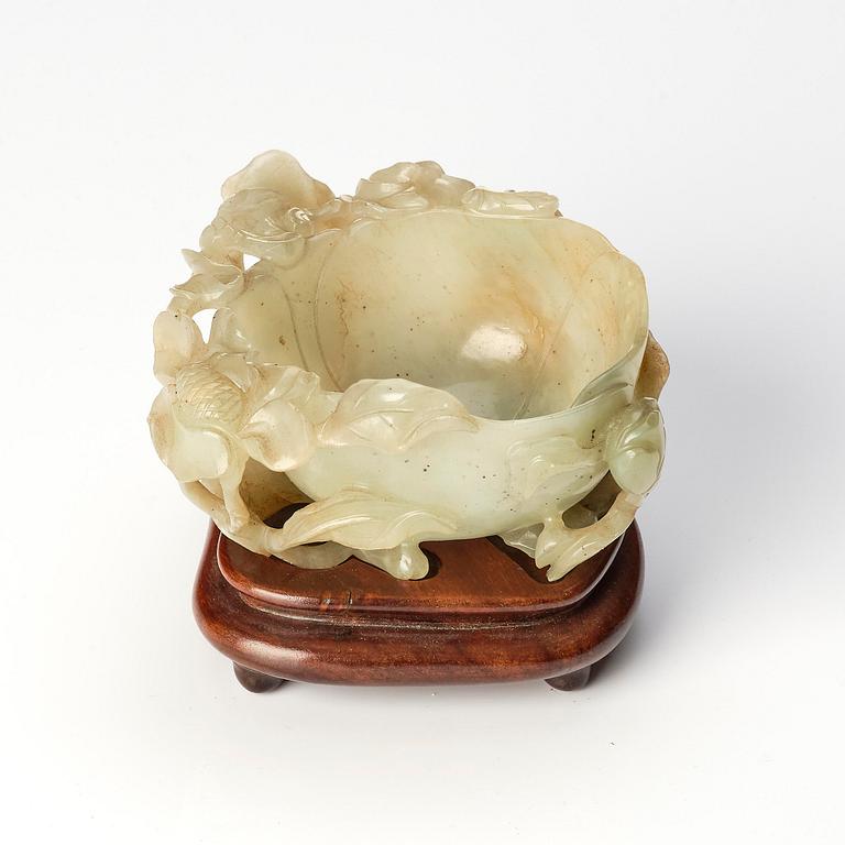 A carved Chinese nephrite cup in the shape of a lotus leaf, late Ming dynasty.