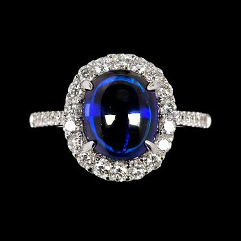 1043. RING, cabochonslipad blå safir, 4.14 ct samt briljantslipade diamanter, tot. 0.68 ct.