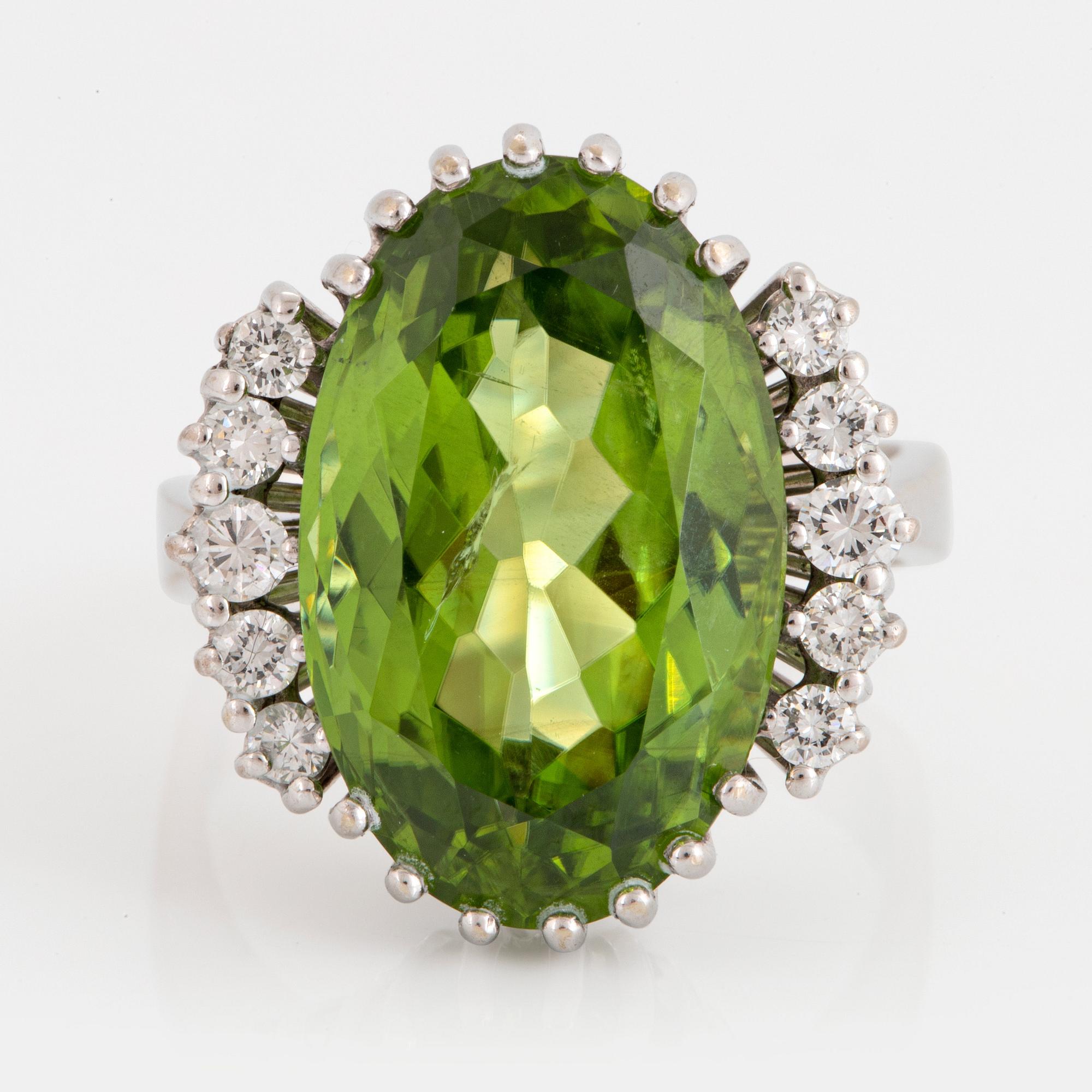 Cocktailring 18K vitguld med en fasettslipad peridot ca 11.00 ct samt runda briljantslipade diamanter.