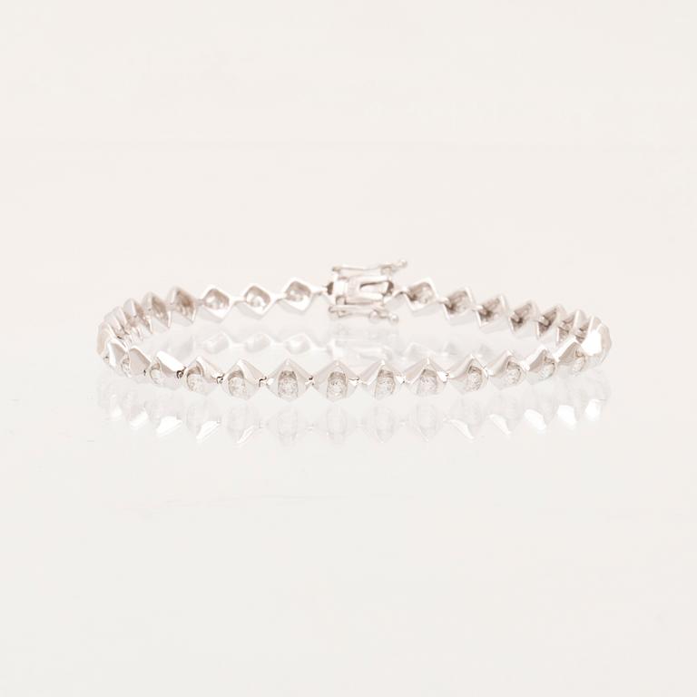 An 18K white gold tennis bracelet with round brilliant-cut diamonds.