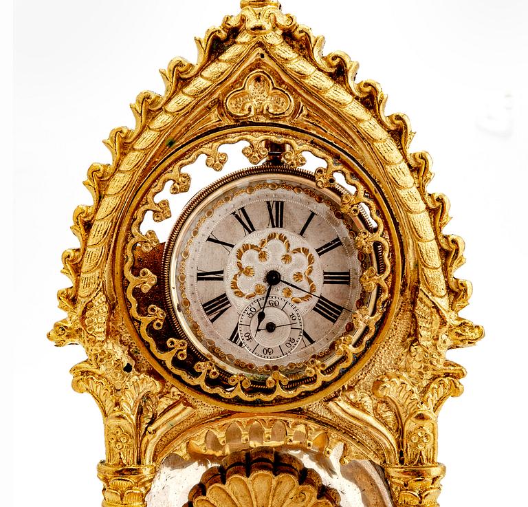 A mid 1800s gilded bronze pocket watch stand and pocket watch.