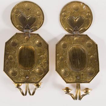A pair of first half of the 20th century brass two-light wall sconces.