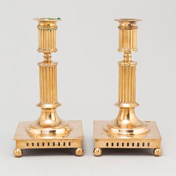 A pair of brass candlesticks, first half of the 20th Century.