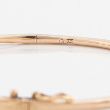 An 18K rose gold bangle set with round brilliant-cut diamonds.