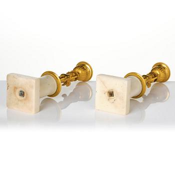 A pair of late Gustavian white marble and ormula candlesticks.