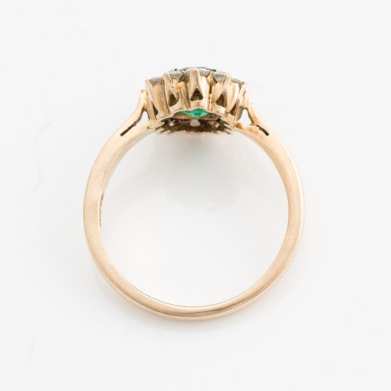 A ring in 18K gold with an emerald and round brilliant-cut diamonds.