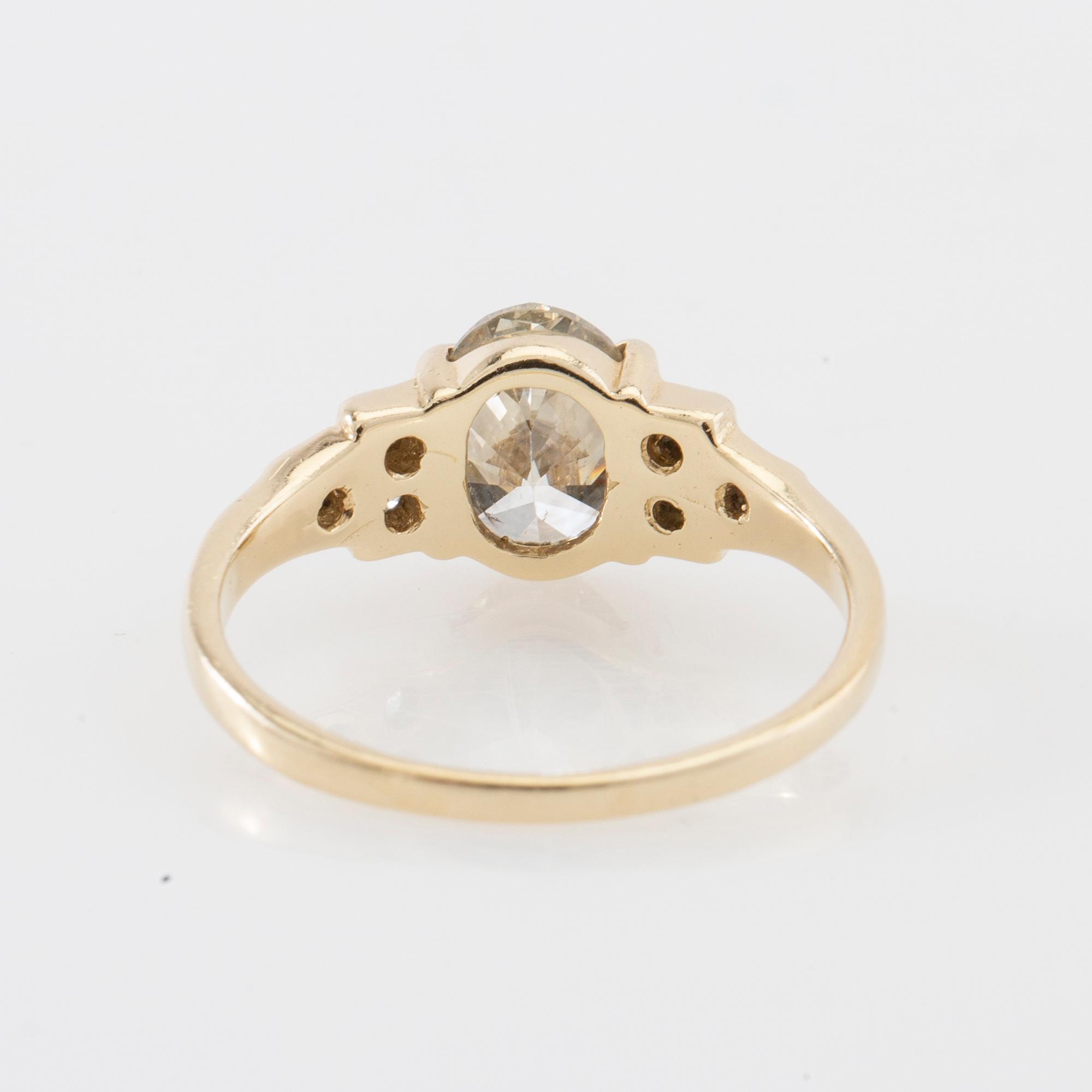 Ring 14K gold with an oval faceted diamond approximately 1.23 ct and round brilliant-cut diamonds.