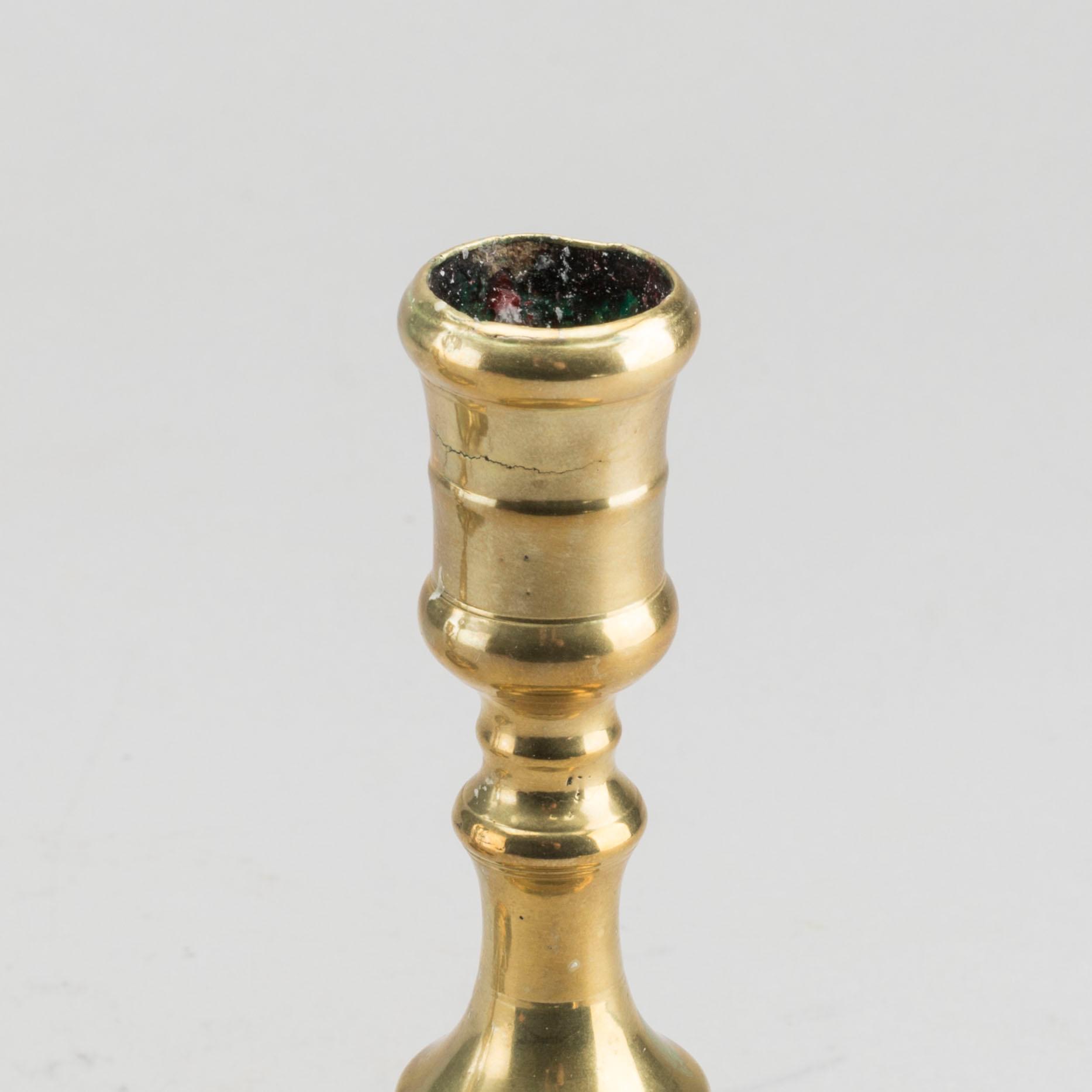 A set of two of brass candle sticks mid 18th century.