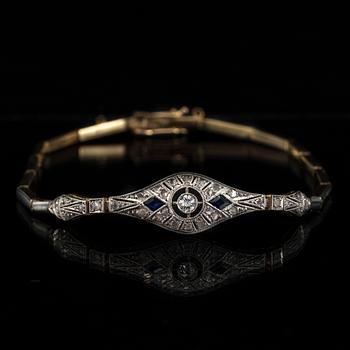 ARMBAND, 18K guld, fasettslipad diamant ca 0.08 ct, 2 blå safirer samt rosenstenar, 1900-talets första hälft. Vikt 8 g.