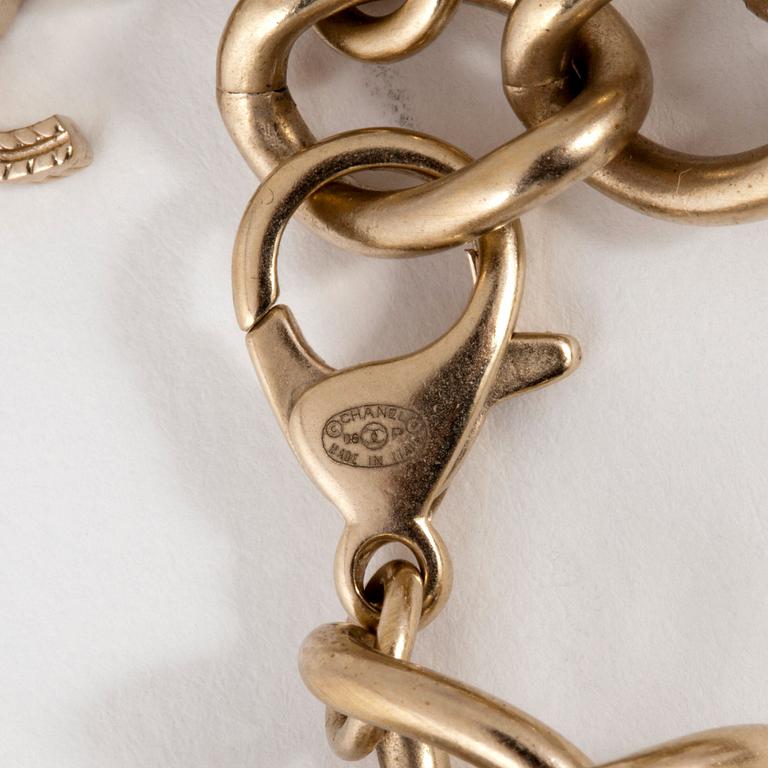 CHANEL, a silvertinted bracelet with decorative pearls and CC-monogram.