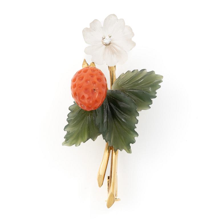 A flower brooch 18K gold with coral, rock crystal, a green stone likely nephrite, and a round brilliant-cut diamond.