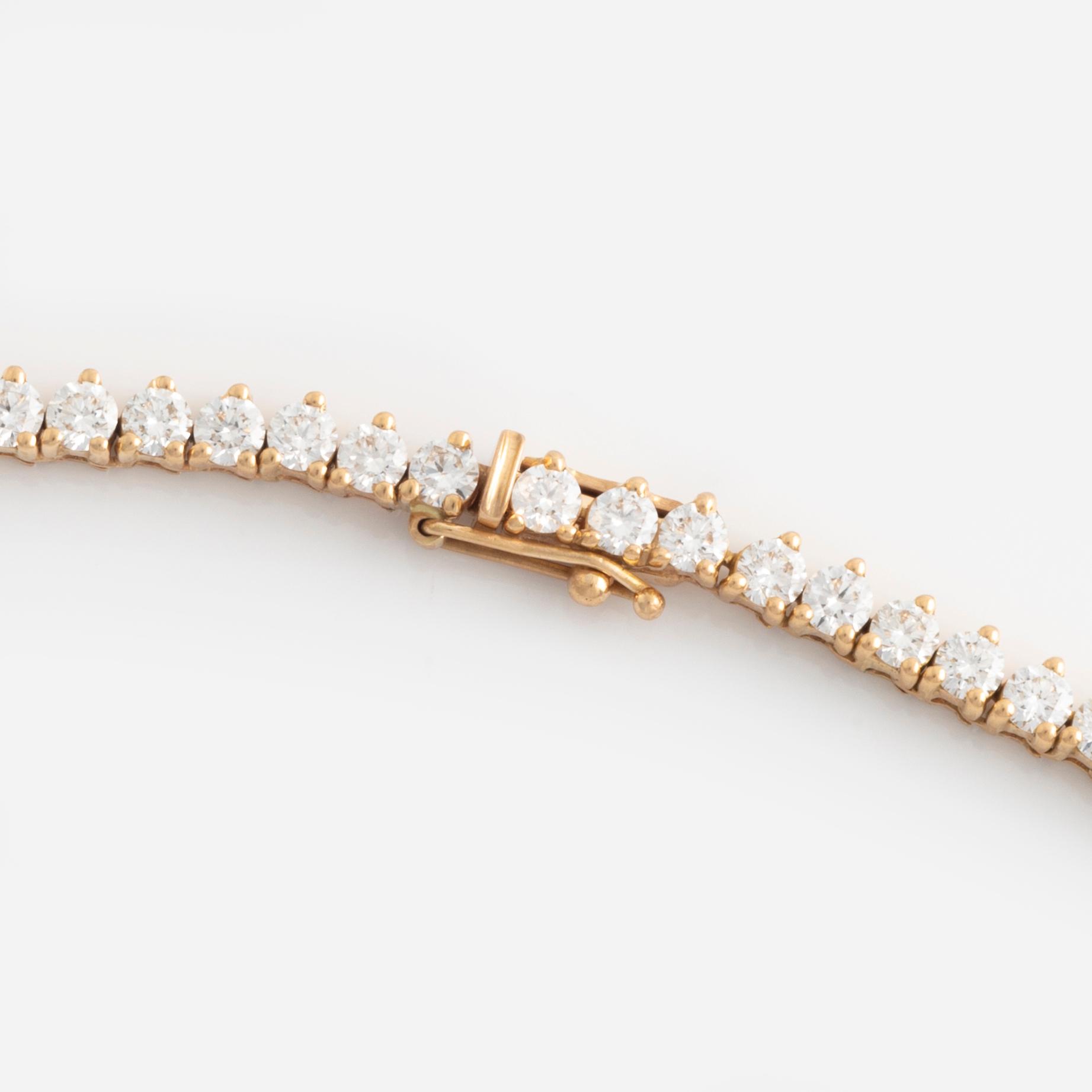 An 18K gold rivière necklace set with round brilliant-cut diamonds.