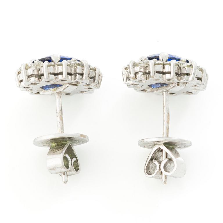 A pair of 14K gold earrings with faceted sapphires and round brilliant- and princess-cut diamonds.