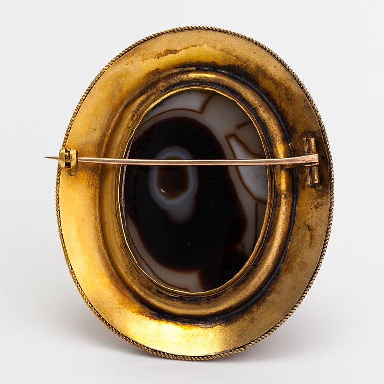 An 18K gold brooch with an onyx cameo and rubies.