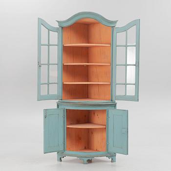 A corner display cabinet, 19th century with a later base.