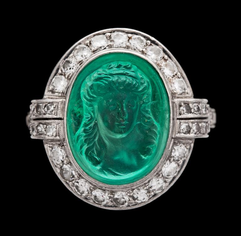RING, kvinnoporträtt av skuren smaragd med briljantslipade diamanter, tot. ca 1.20 ct. 1930-tal.
