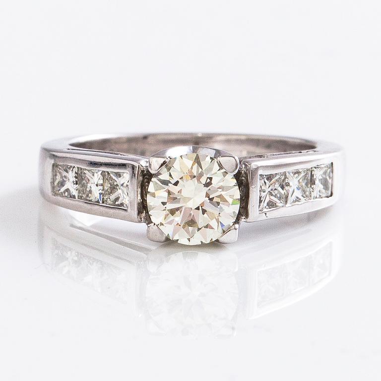 An 18K gold ring with a brilliant-cut diamond ca. 1 ct and princess-cut diamonds ca. 0.7 ct in total.