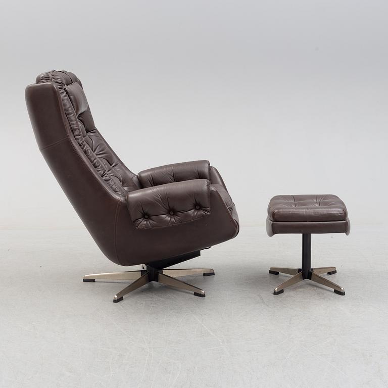 A leather upholstered easy chair with foot stool, 1960's/70's.
