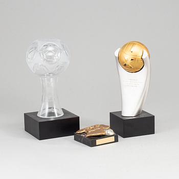 A collection of three soccer sculptures.